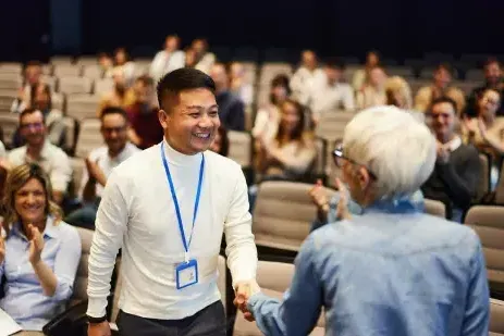 two people shaking h和s at a conference event
